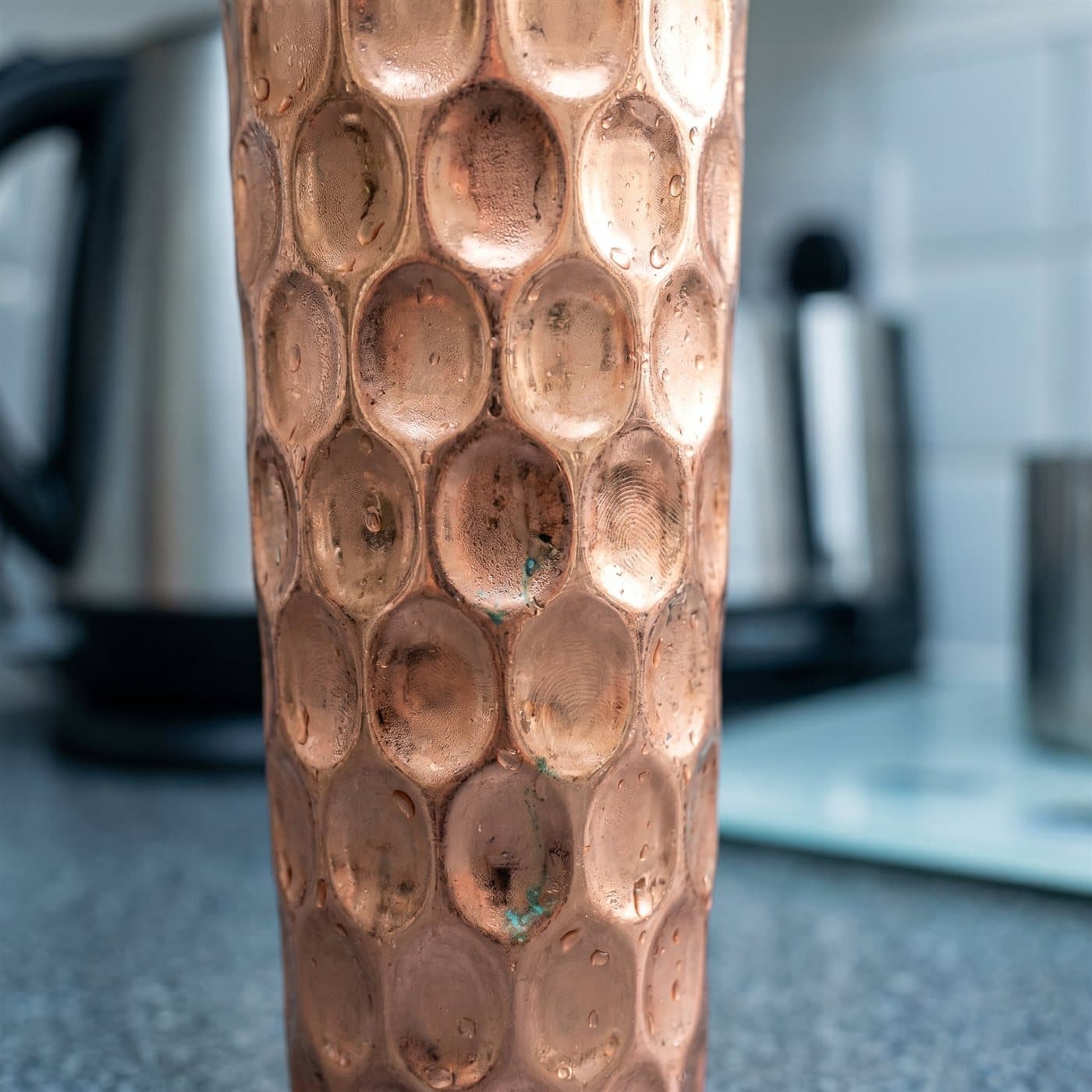 Close-up of the hand-hammered honeycomb dimples on a copper tumbler